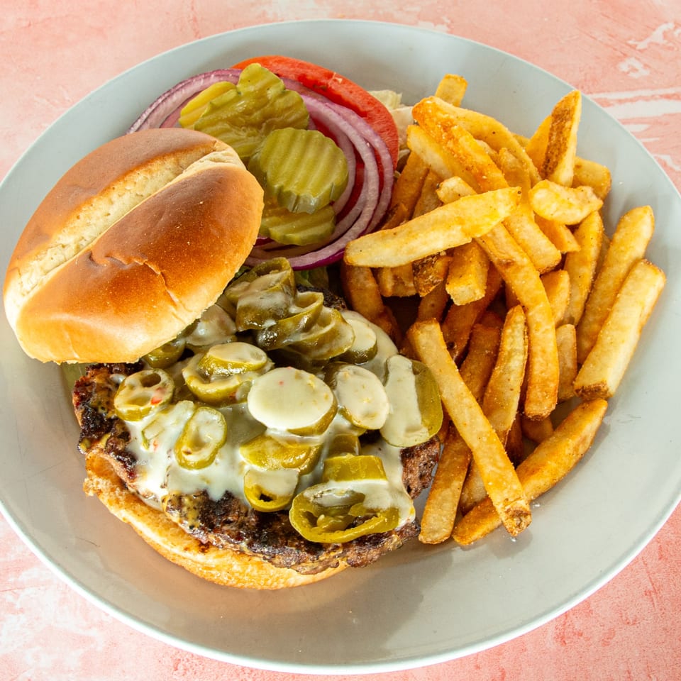 Redbone's Grill & Bar's burger with melted cheese, jalapeños, and a side of golden fries.