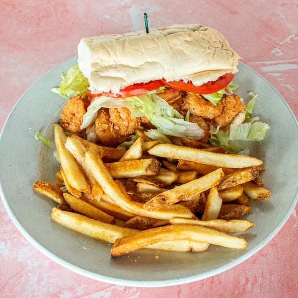 Redbone's Grill & Bar's fried shrimp po'boy with lettuce, tomato, and a side of fries.