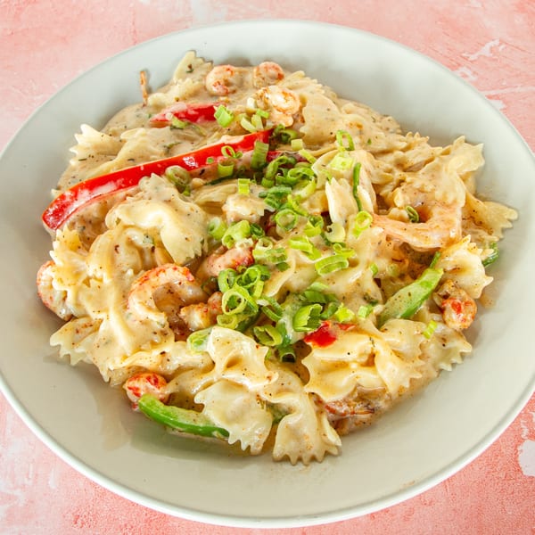 Creamy Cajun pasta with shrimp, crawfish, red and green bell peppers, and green onions.